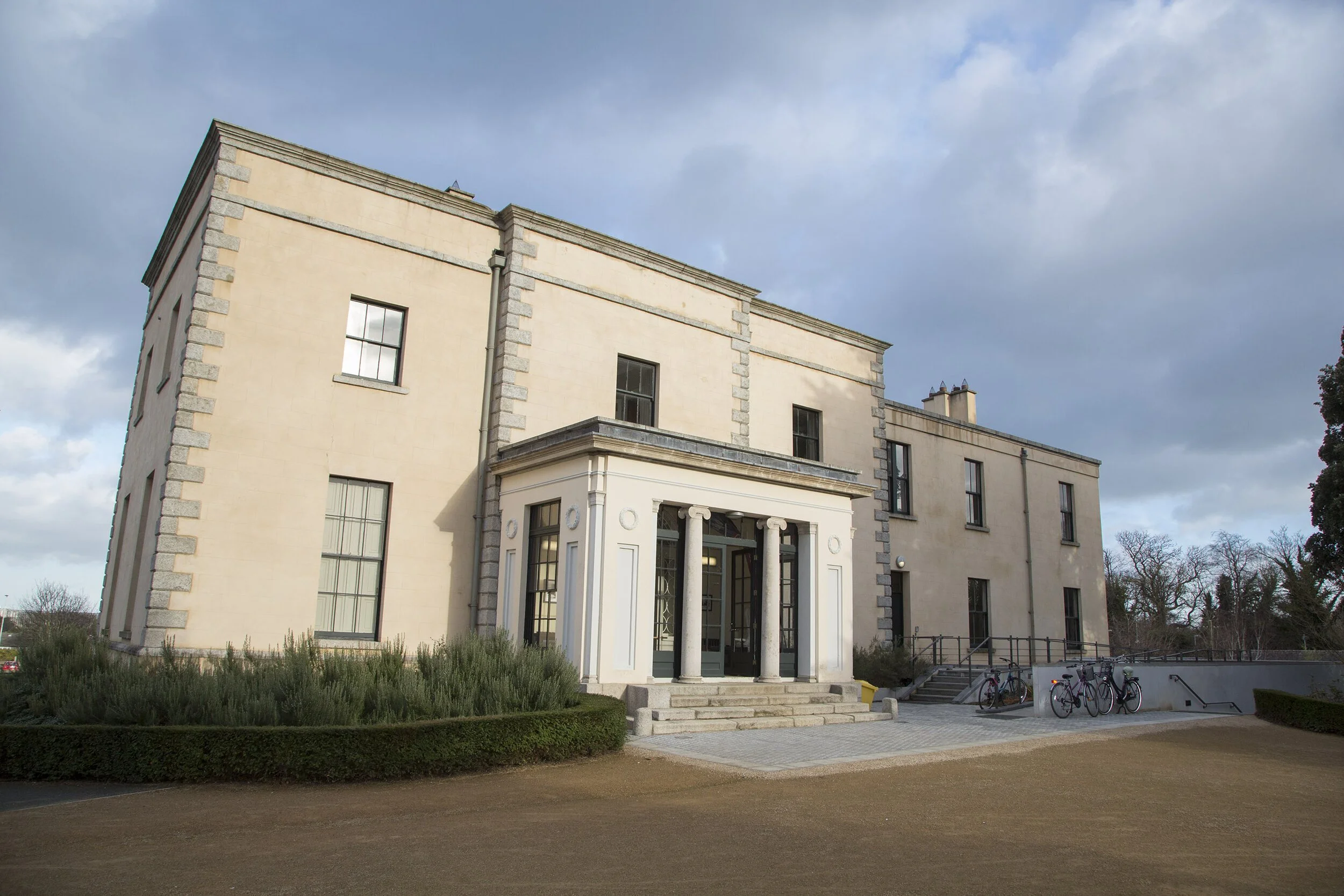 Pale cream building with Romanesque columns.